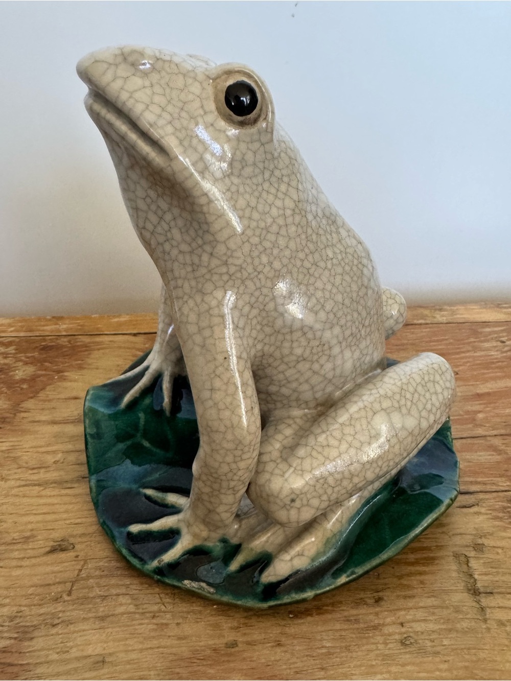 Ceramic frog figurine with crackle glaze on lily pad base
